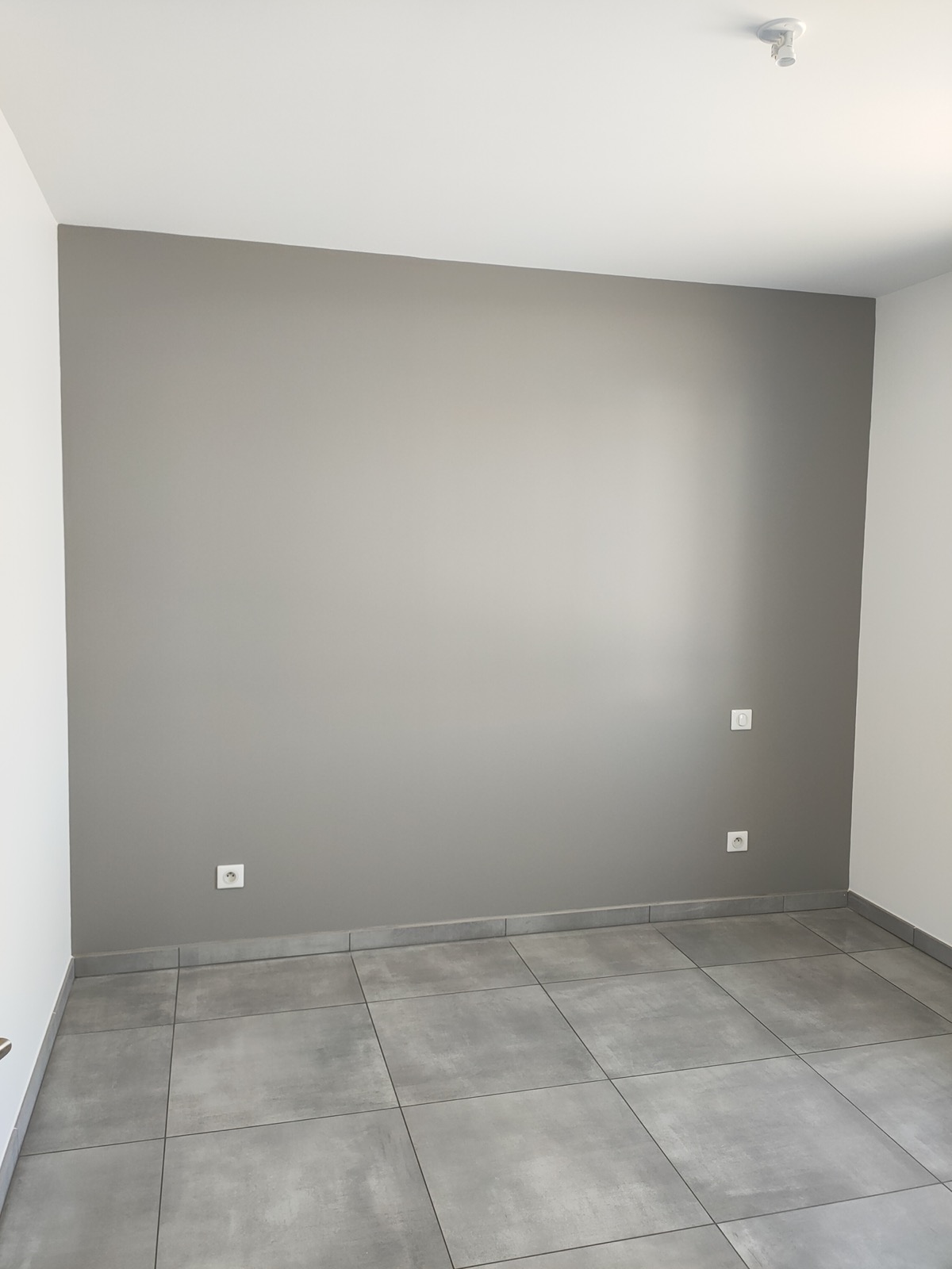 Pièce avec un mur peint en gris et carrelage gris, par la SARL VIDIEU